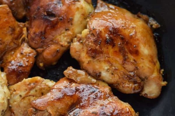 Chicken in a skillet with sauce on it.