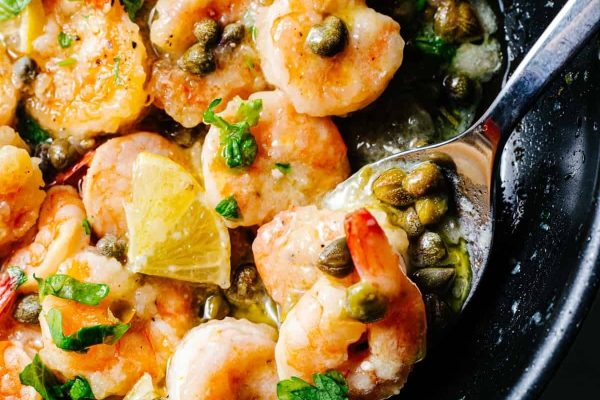 Shrimp with lemon and capers in a skillet.