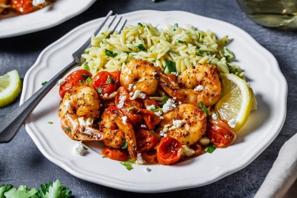 A plate with shrimp and tomatoes on it.
