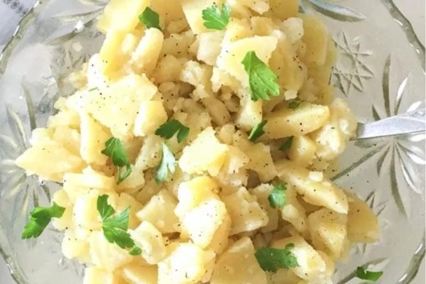 A cheap bowl of potatoes with parsley, perfect for a potluck dinner.