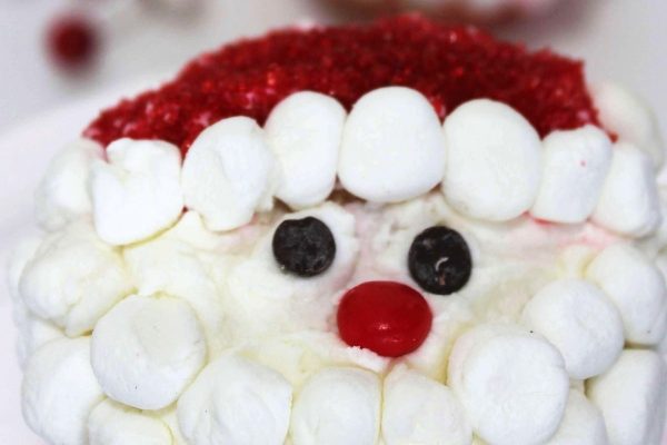A santa claus shaped marshmallow on a plate, perfect for Christmas treats.