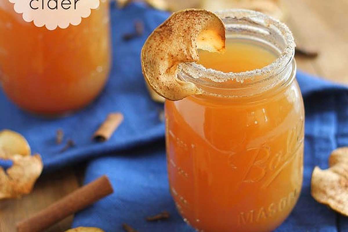 Two mason jars filled with fall-inspired apple cider and cinnamon cocktails.
