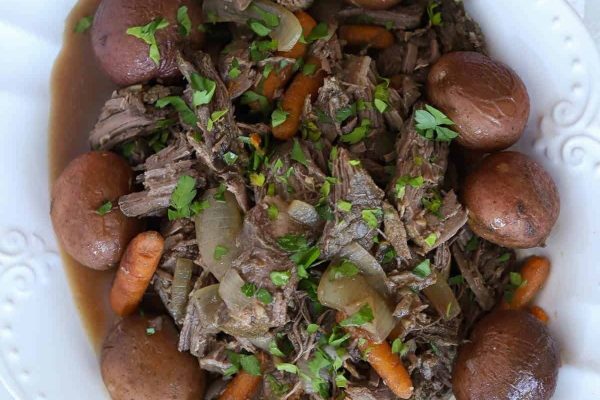 A plate of beef stew with carrots and potatoes.