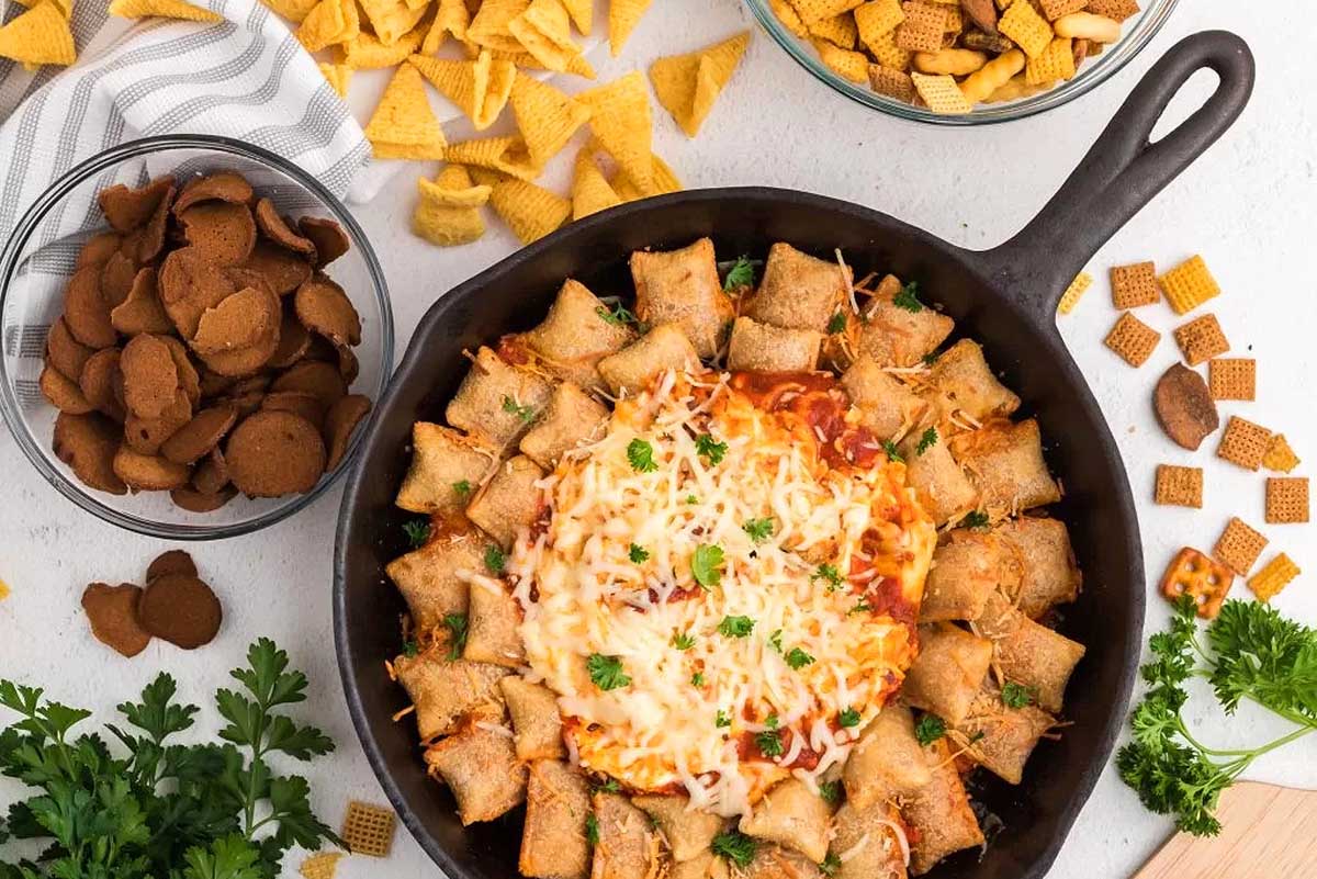 Cheesy nacho dip in a cast iron skillet.