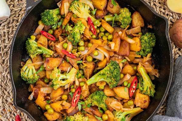 A breakfast skillet filled with broccoli, potatoes and peas for meal prep.
