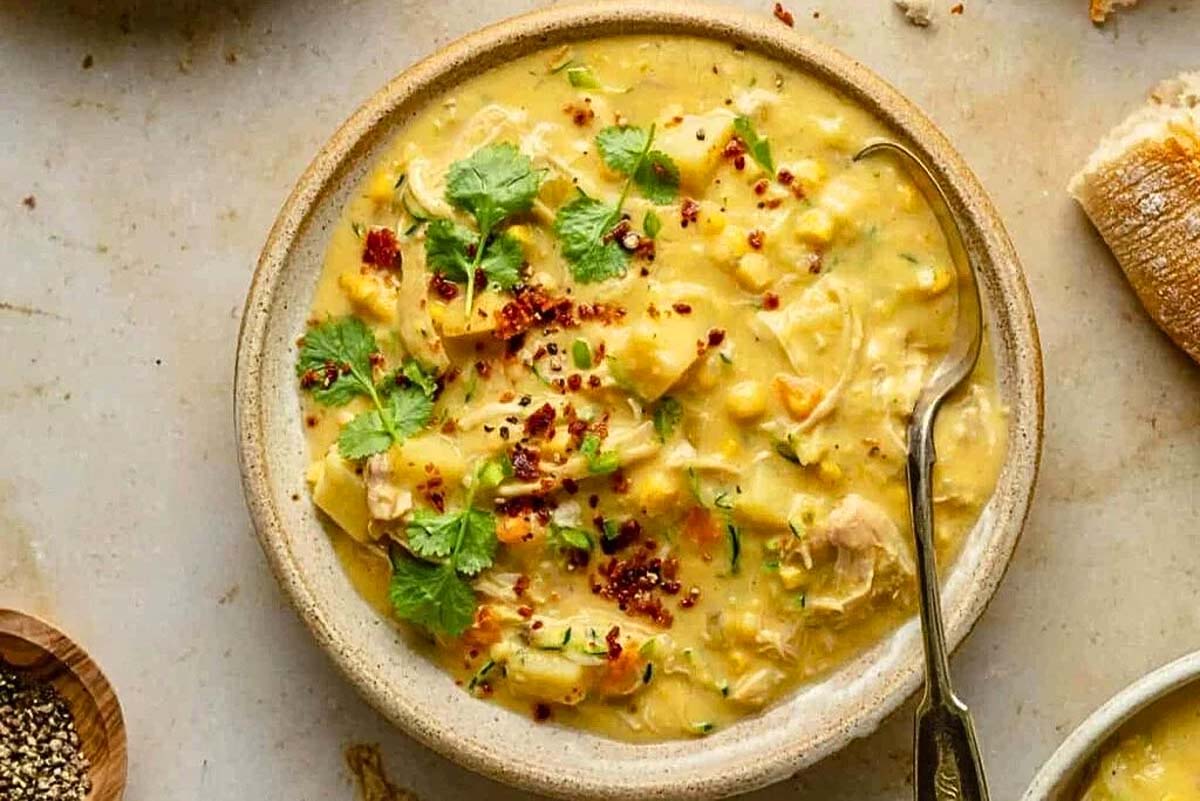 A warm bowl of slow cooker chicken noodle soup on a table.
