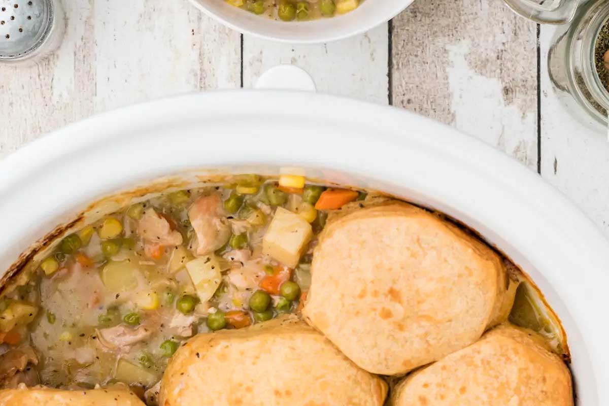 Chicken biscuits and gravy in a white crock pot.