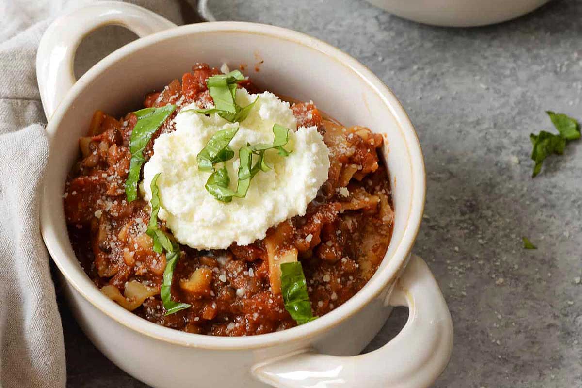 A savory bowl of slow cooker meatballs topped with sour cream.