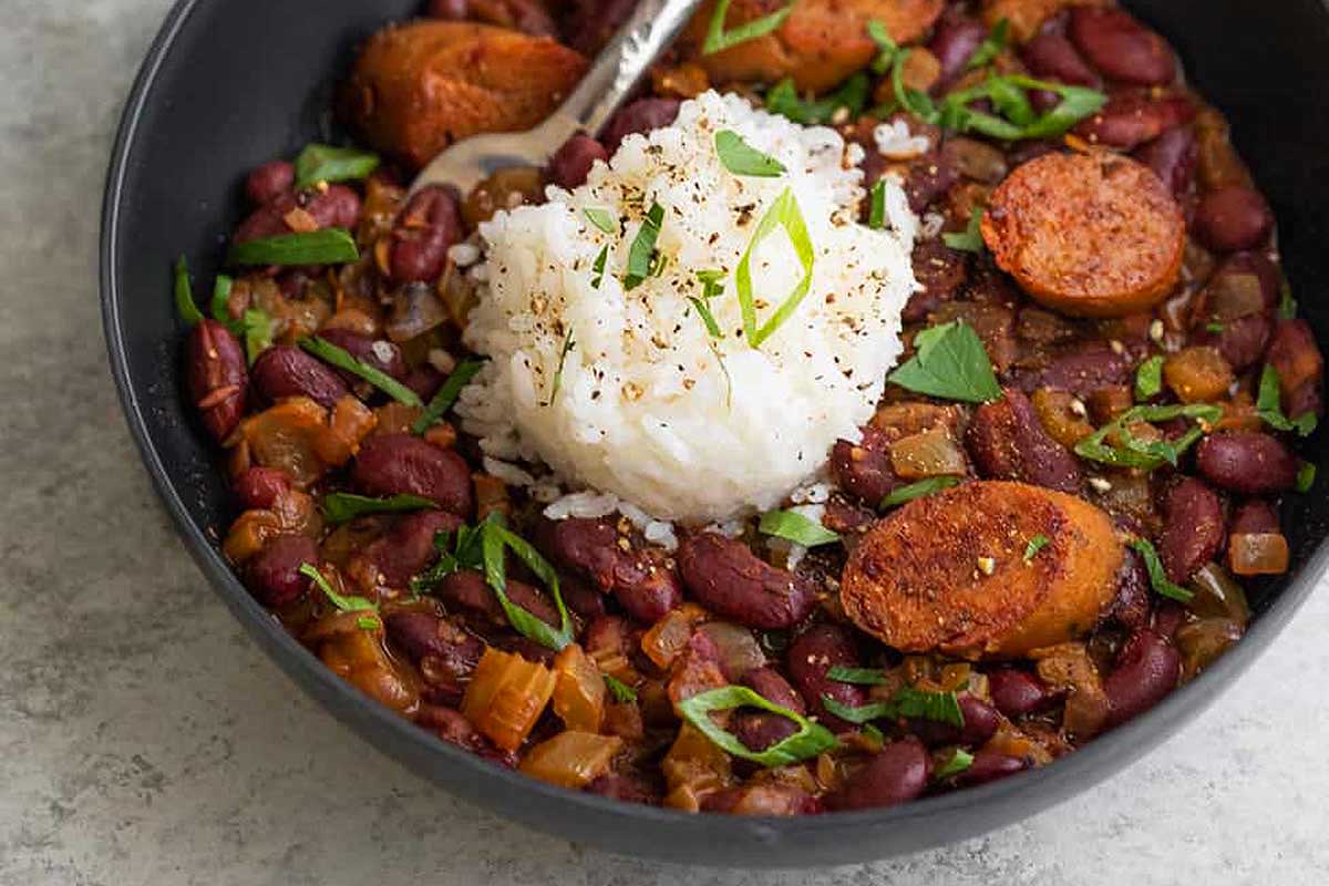 A bowl of beans and rice with a spoon.