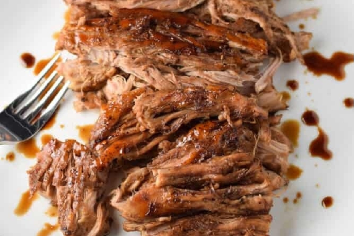 Slow cooker pulled pork on a plate with a fork.