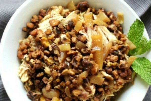 A white bowl with a lot of food in it.
