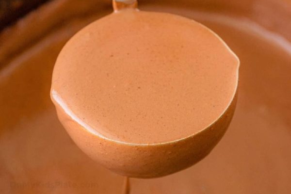 Chocolate sauce being poured into a bowl.