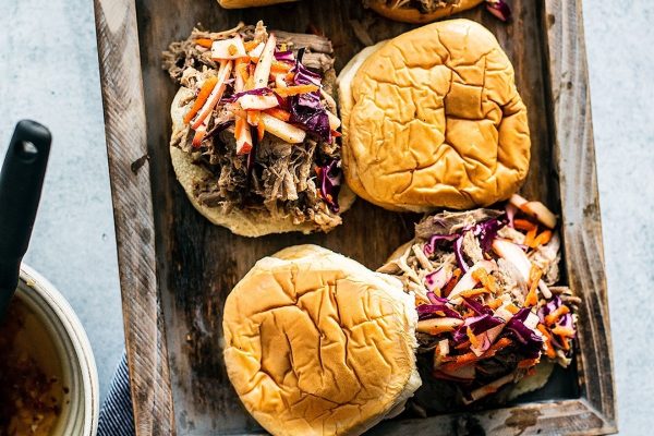 Bbq pulled pork sliders on a wooden cutting board.