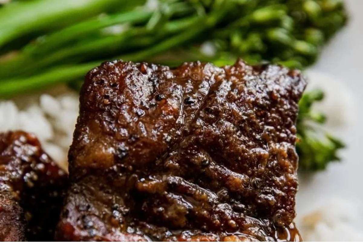 A delicious plate of ribs served with rice and broccoli.
