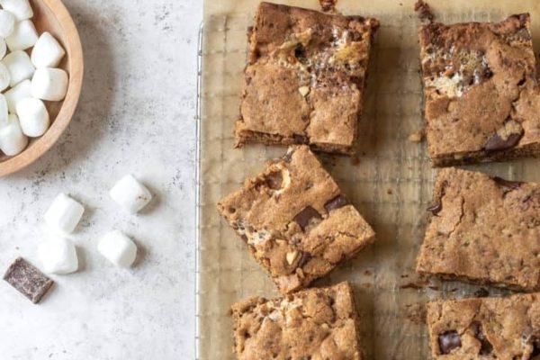 Chocolate s'mores bars on a baking sheet with marshmallows.