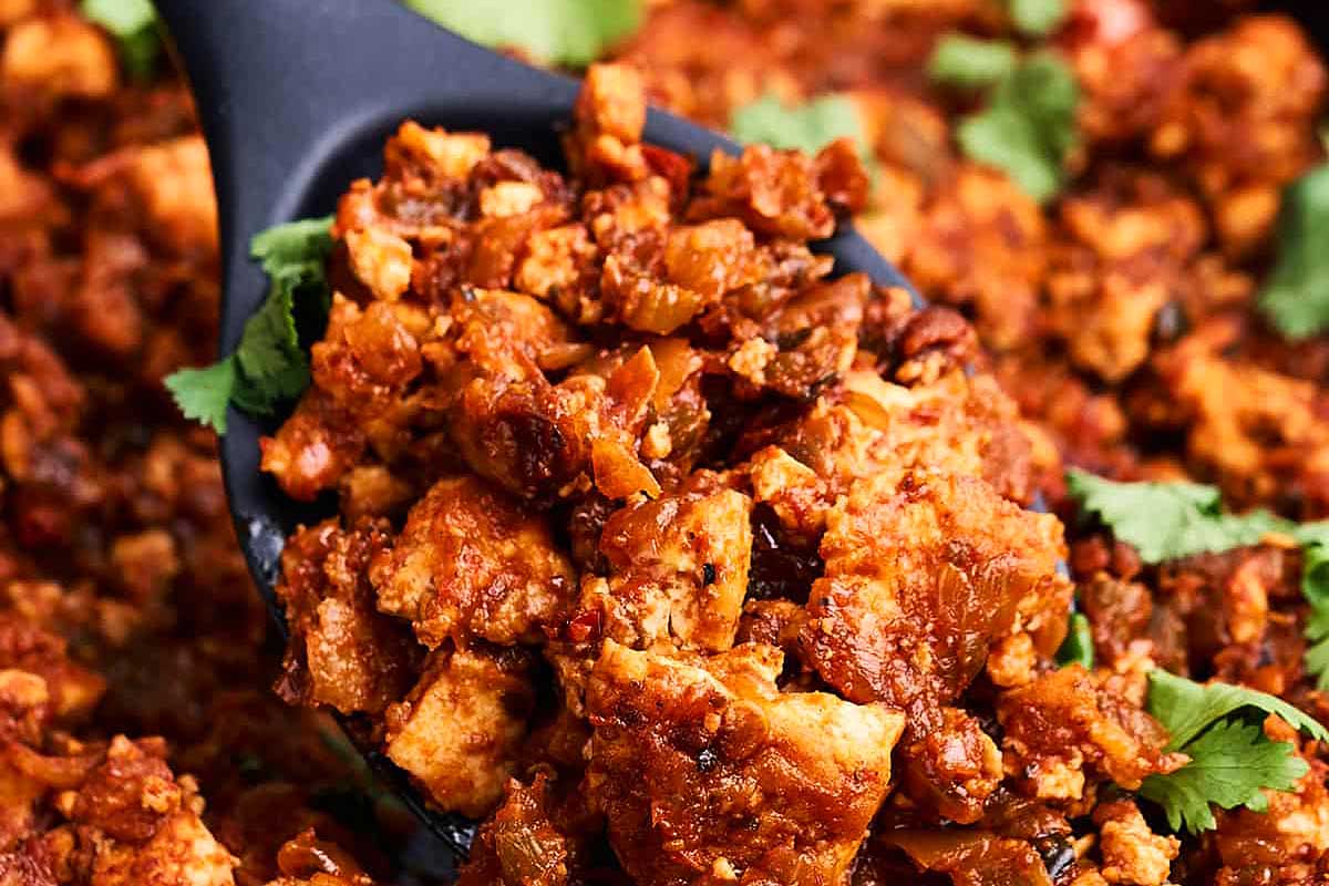 A spoonful of meat in a skillet.