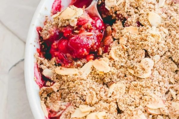 A dish with a scoop of cranberry crisp.