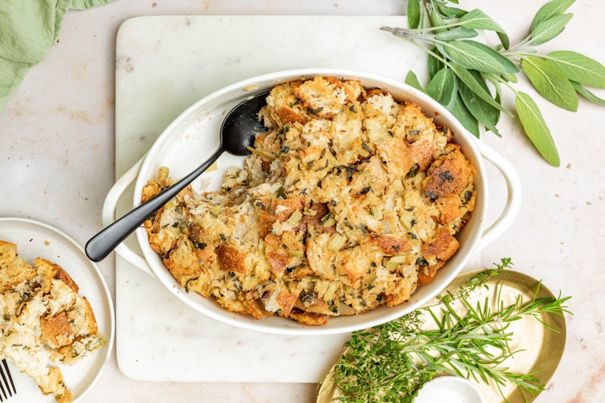A white dish with stuffing and sprigs of sage. This simple recipe is perfect for savory stuffing lovers.