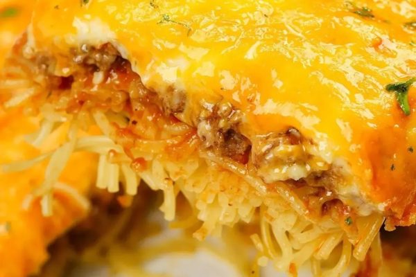 A close up of a piece of cheese and meat lasagna.