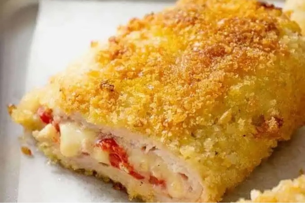 A tantalizing dinner party main course - a succulent piece of chicken stuffed with cheese and tomato served on a baking sheet.