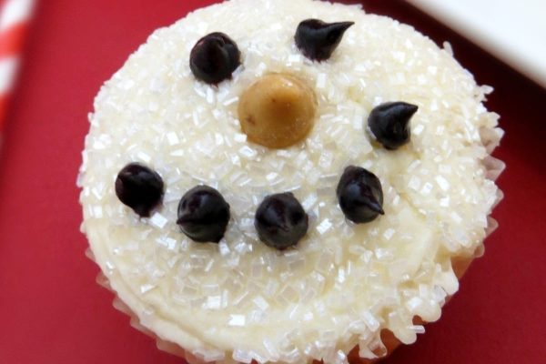 A Christmas cupcake decorated with white frosting and chocolate chips.
