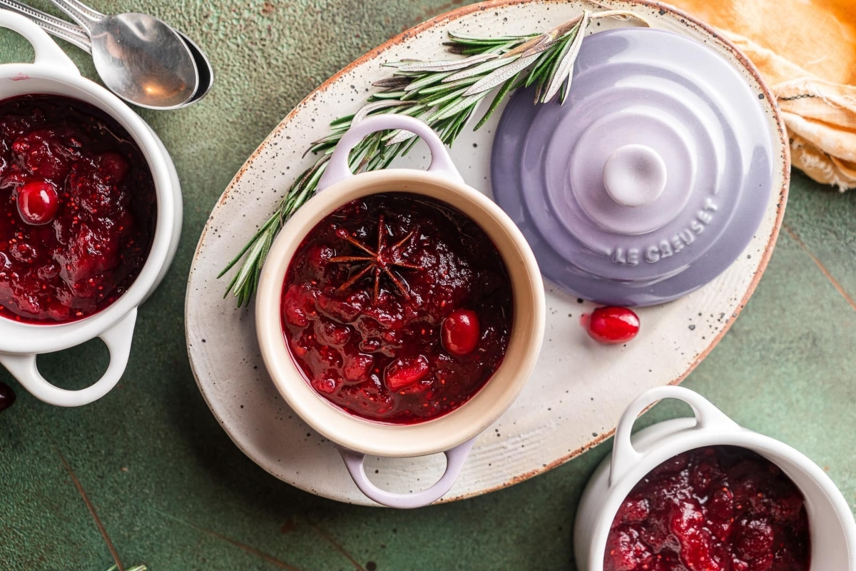 Three bowls of cranberry sauce, perfect for holiday recipes, displayed on a table.
