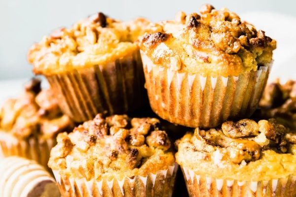 A stack of muffins with nuts on top.