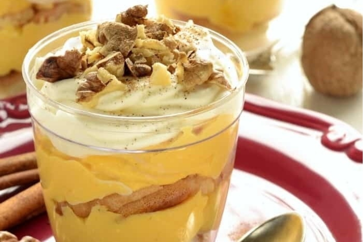 A Trifle with whipped cream and cinnamon on a plate.