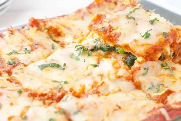 Lasagna with spinach and cheese in a baking dish.