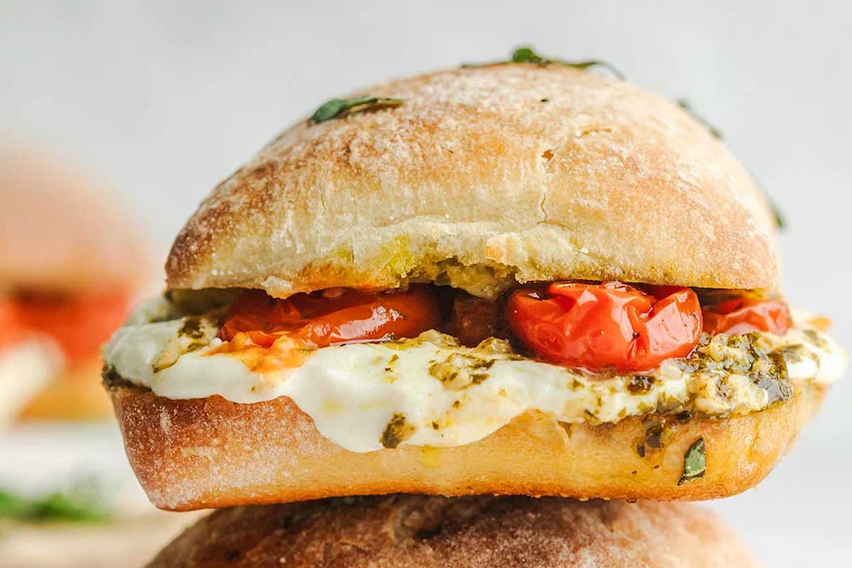 A stack of sandwiches with pesto and tomatoes, ideal for tomato recipes.
