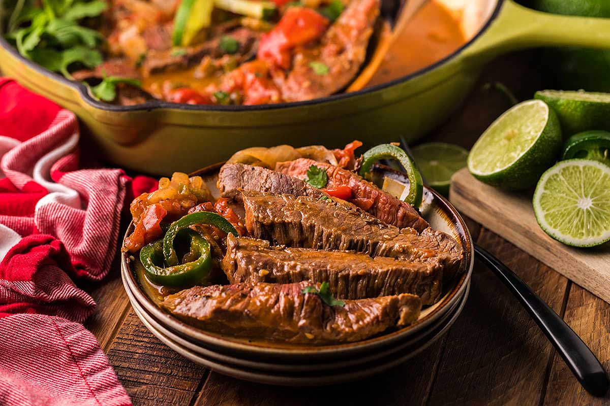 A bowl of beef stew on a wooden table.
