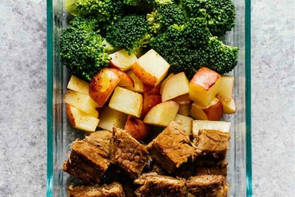 Beef, broccoli and potatoes in a glass container.