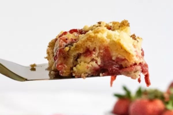 A piece of strawberry crumb cake on a fork.