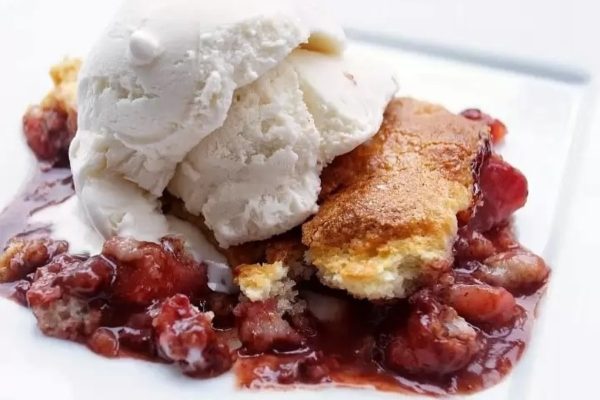 Cherry cobbler with ice cream and a scoop of ice cream.
