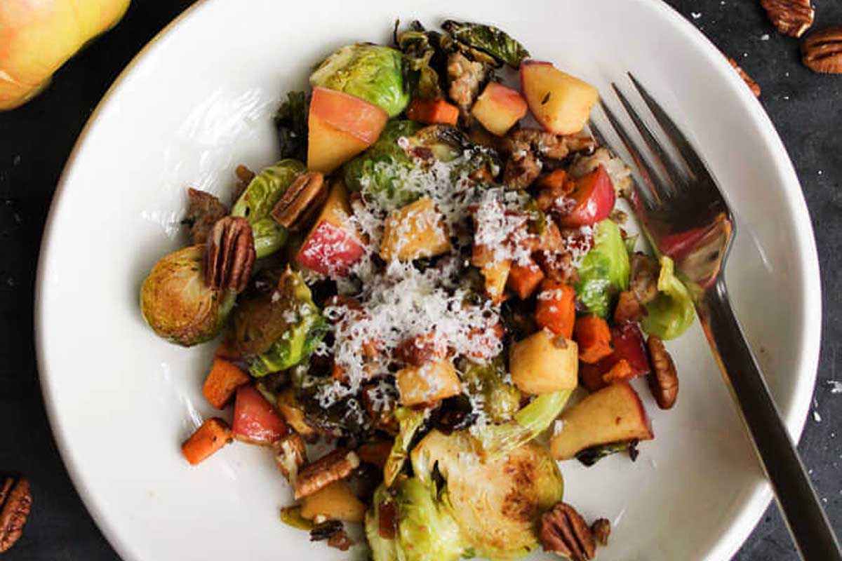 Brussels sprouts, apples and pecans on a plate.