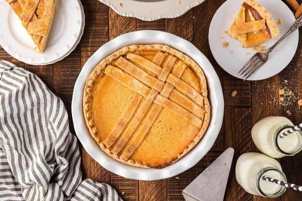 A slice of pumpkin pie on a wooden table.