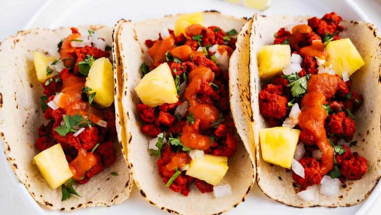 Three chicken tacos on a white plate.