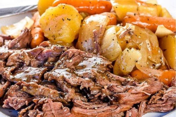 A plate of roast beef with carrots and potatoes.