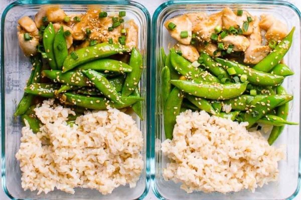 Two glass containers with rice and green peas.