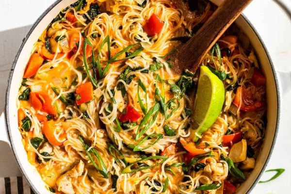 Budget-friendly Thai chicken noodle soup in a pan, perfect for take-out meals.
