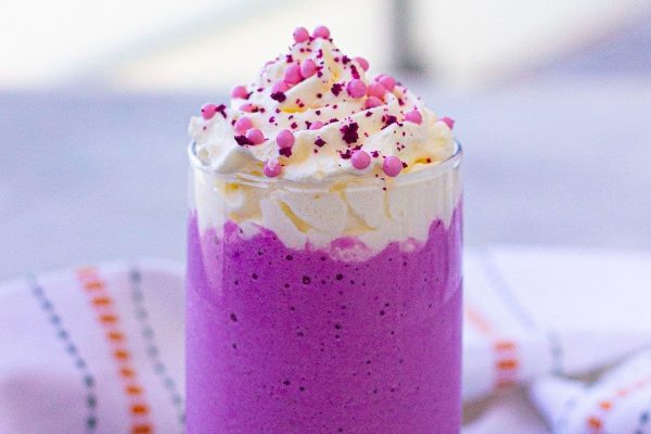 A purple milkshake recipe with whipped cream and sprinkles.