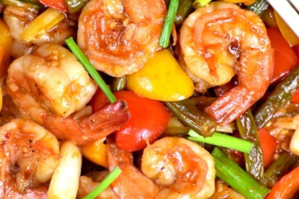 An Asian-inspired plate of seafood and vegetables stir-fried in a wok.