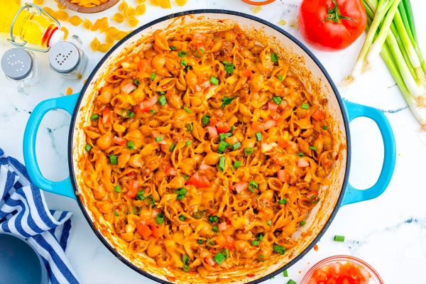 A bowl of pasta with kid-friendly recipes featuring meat and vegetables, that parents love, on a table.