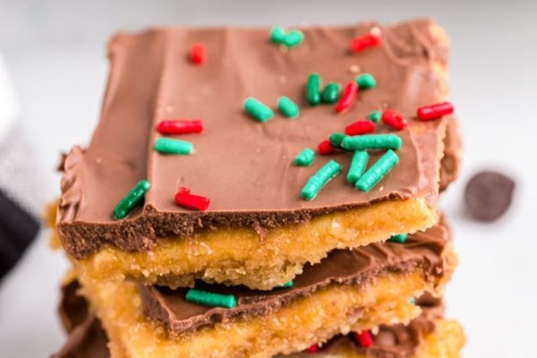 A stack of chocolate oreo bars with sprinkles on top.