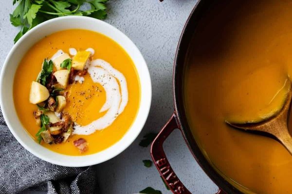 A classic bowl of butternut squash soup with sour cream and parsley.