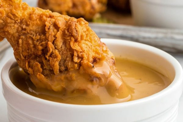 Fried chicken with gravy in a white bowl.