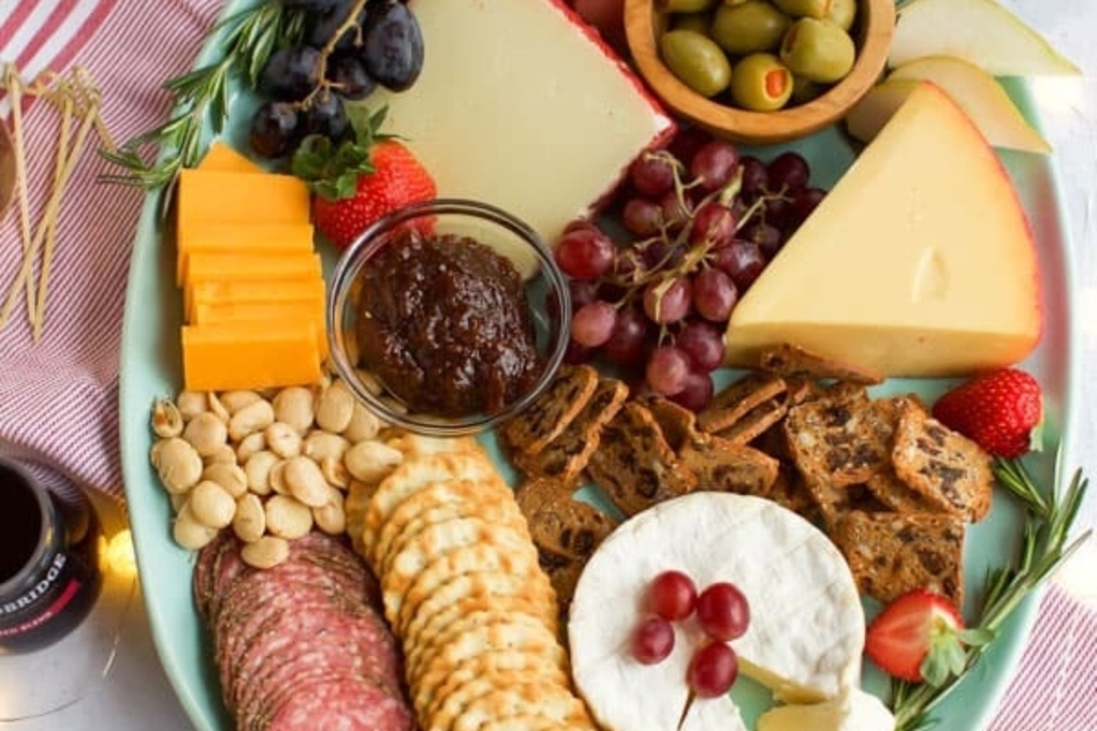A Christmas party appetizer featuring a plate with cheese, crackers, grapes, and nuts.