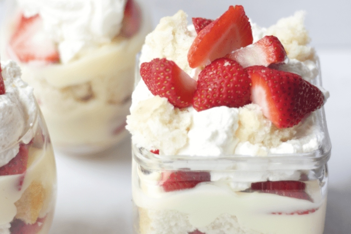 Christmas trifle in a jar with whipped cream and strawberries.