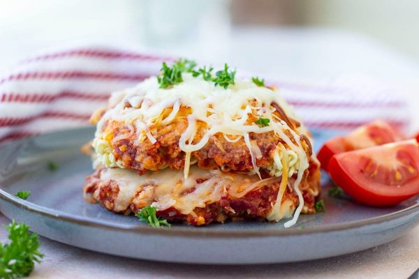 A plate with a pizza topped with cheese and tomatoes.