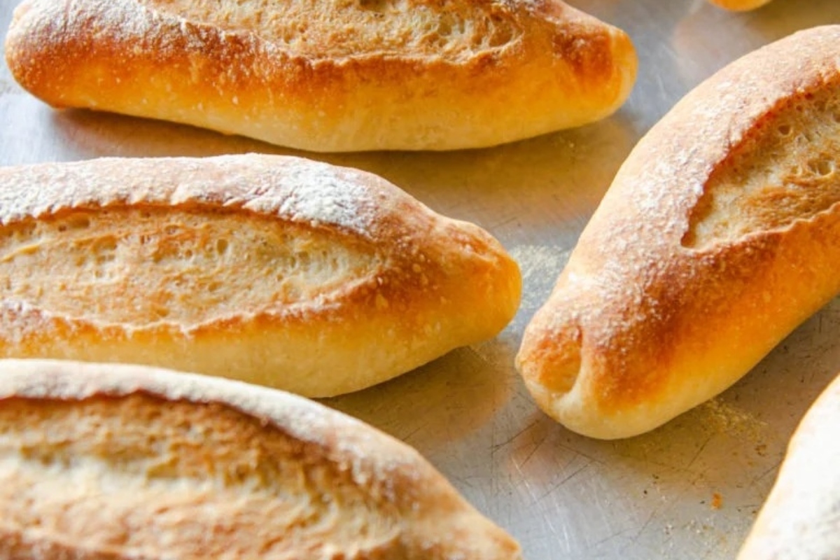A collection of bread rolls arranged on a baking sheet.